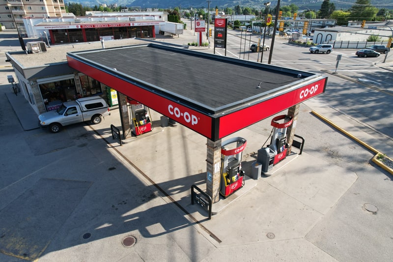 Completed torch-on re-roof over a gas station, seen from the air