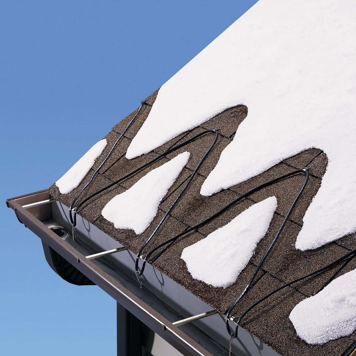 Heat trace cable melting drainage channels through snow on a shingle roof