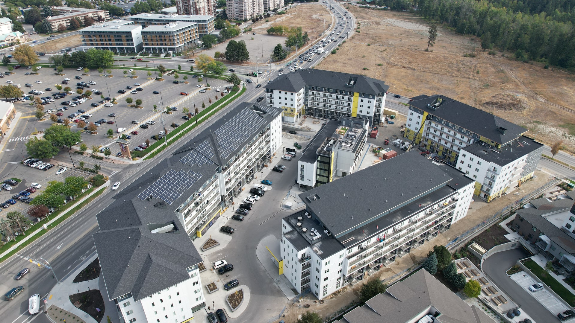 Aerial view of a multi-storey building under construction, its roof being shingled
