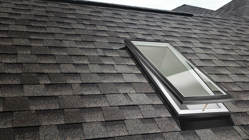 A venting skylight standing open on a shingle roof