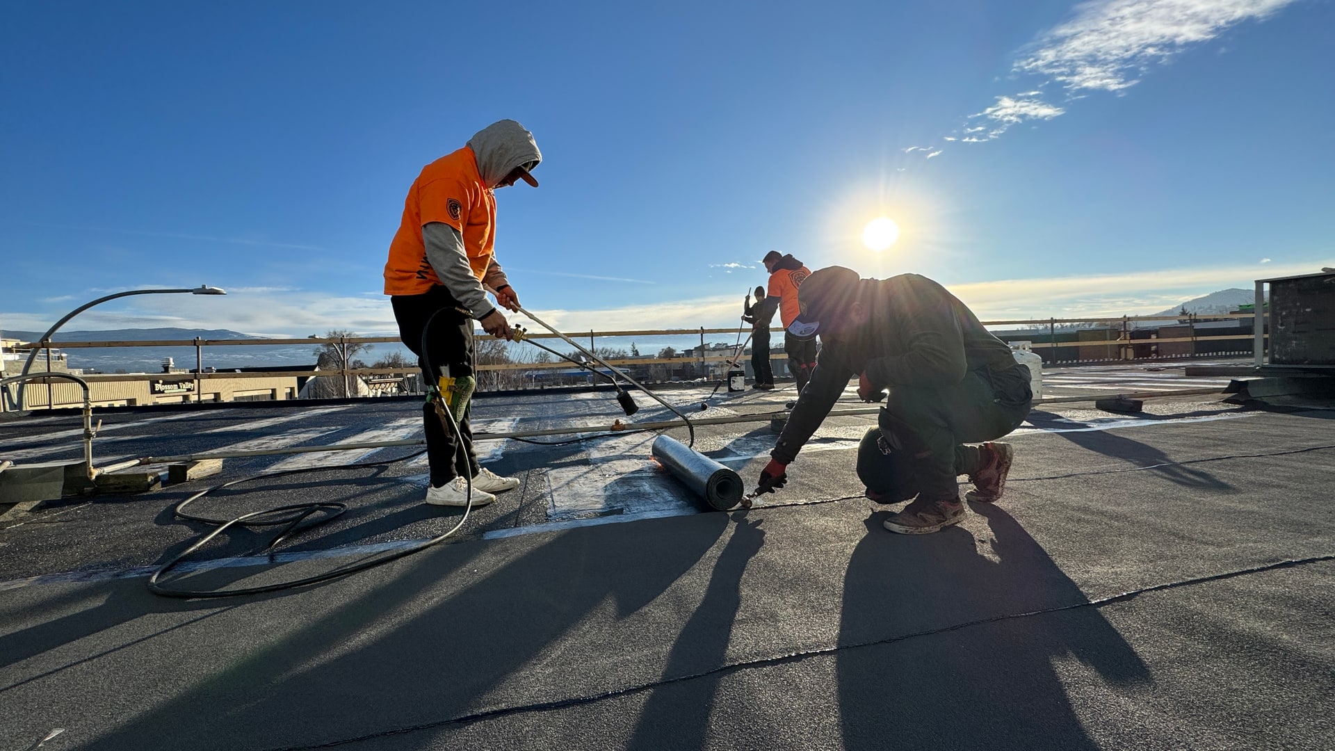 Torch-applied SBS membrane being laid over an existing flat roof